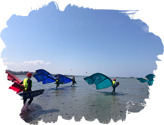 Groupe de kitesurfeurs sur le sable