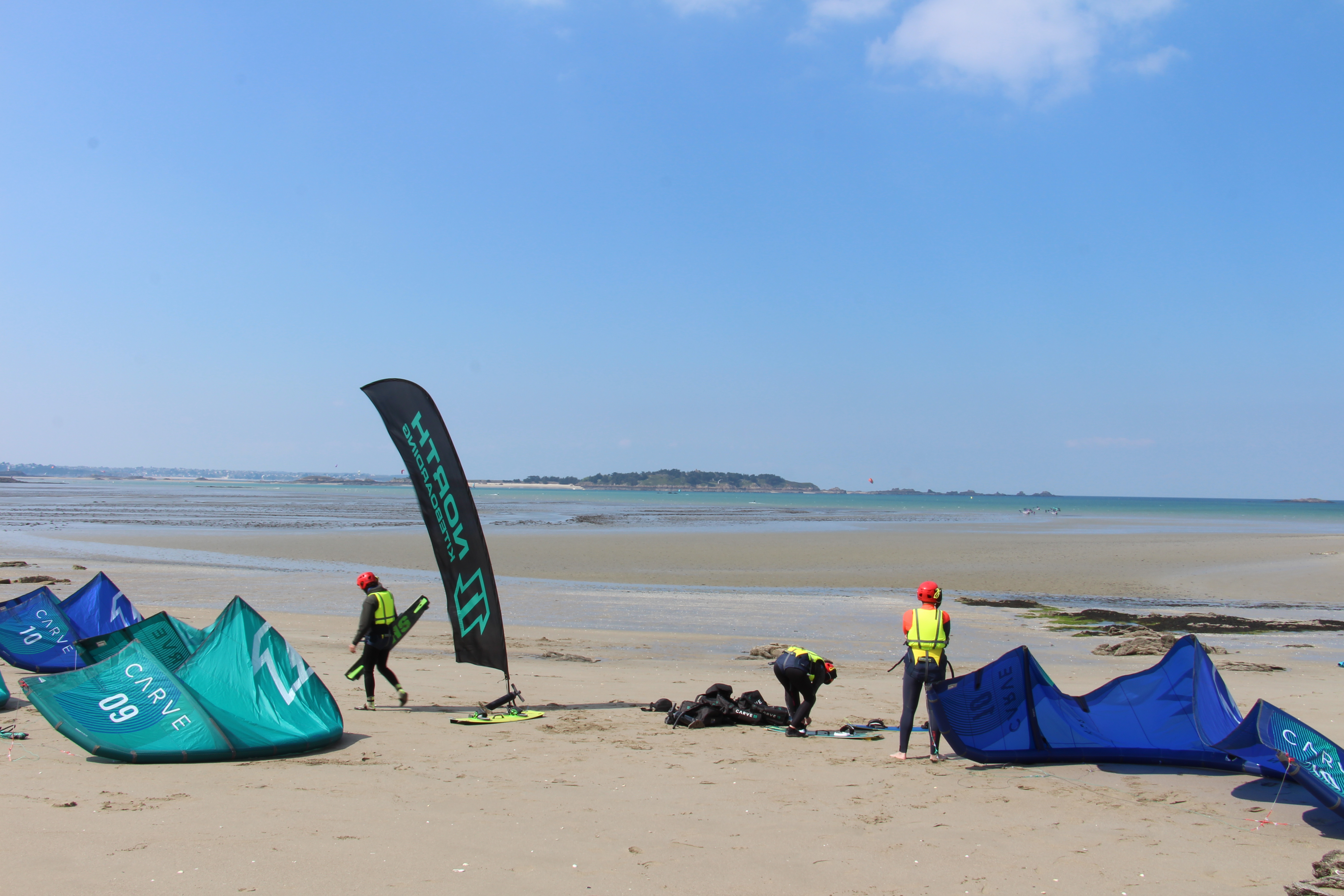 Vue sur un drapeau planté sur le sable avec la mer eu loin